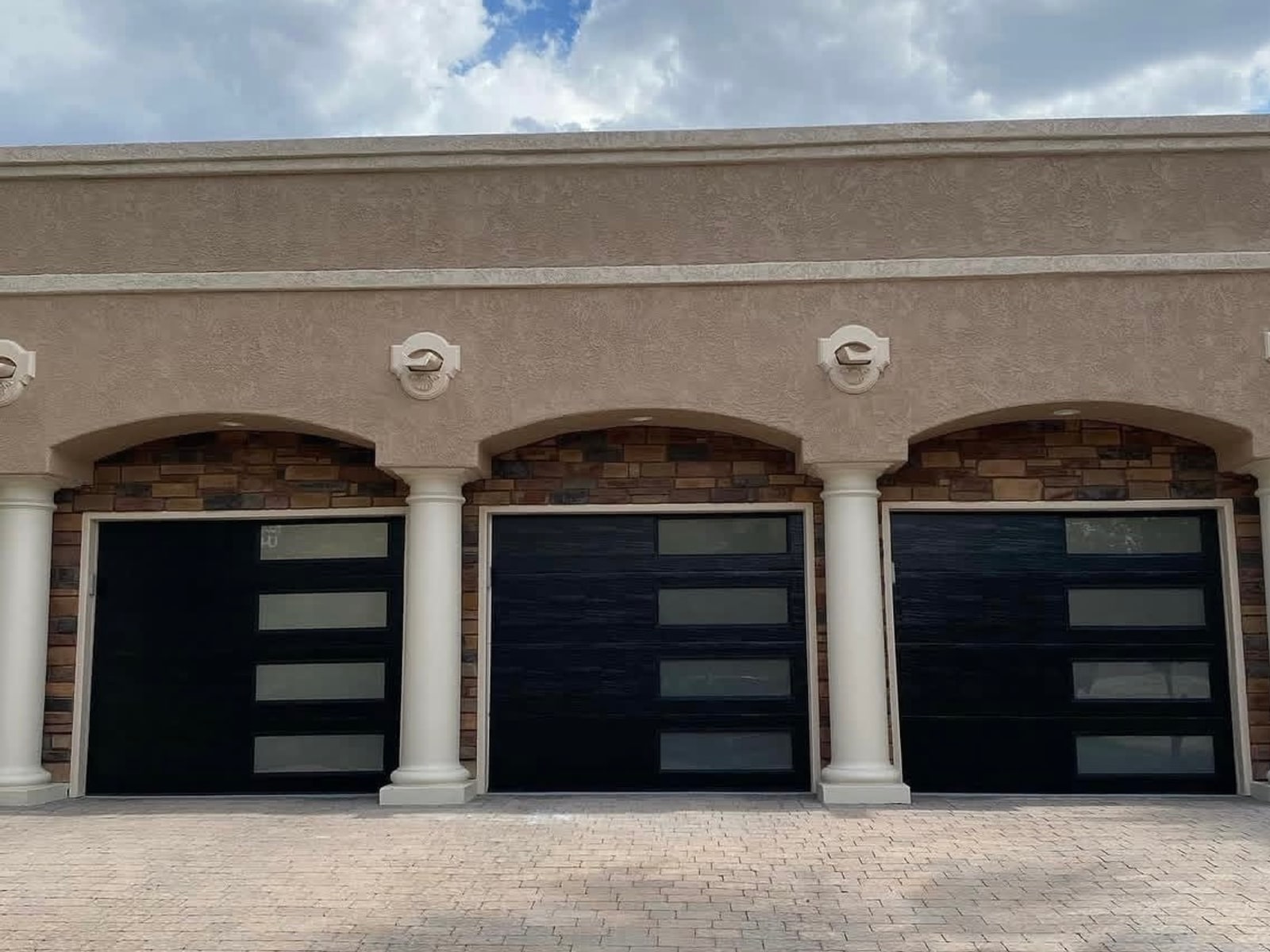 Three full-view black glass garage doors